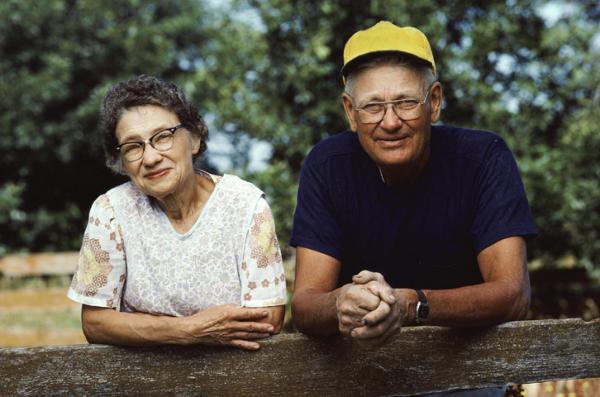 Older couple leaning on fence