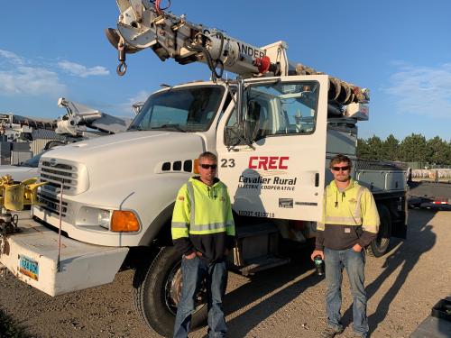 Cavalier Rural Electric Cooperative crew stand next to their line truck