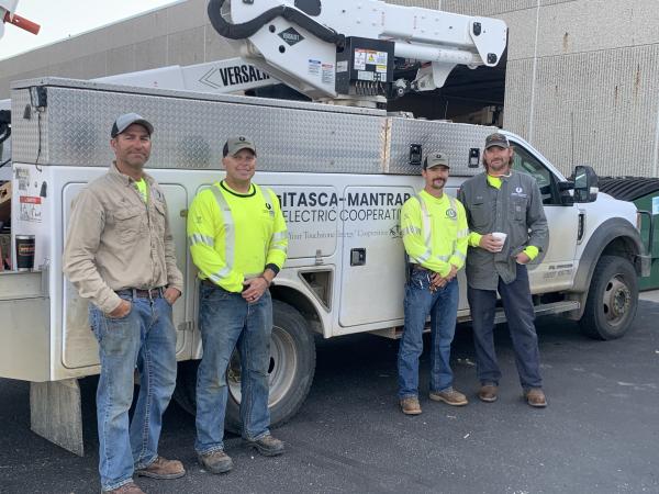 Itasca-Mantrap Electric Co-op crews standing next to a linetruck