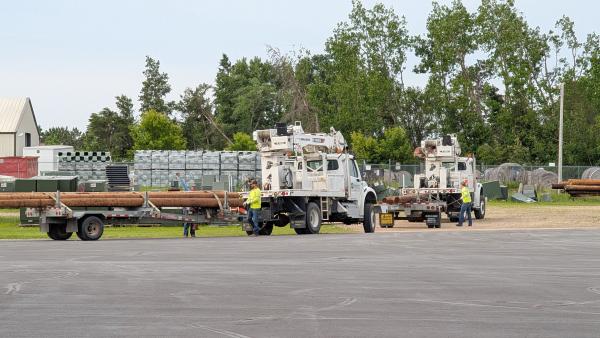 Two BEC trucks load poles for restoration work