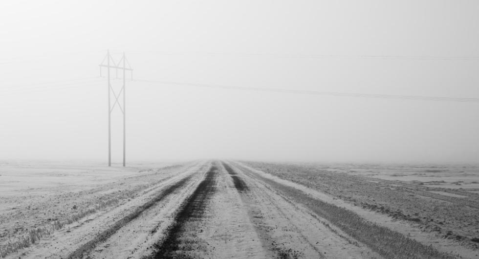 View of winter road with power line in distance