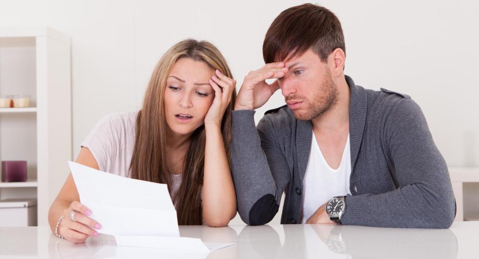 Young couple looking at bill at table