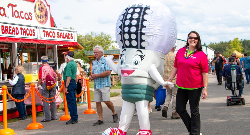 Mascot LED Lucy walks the grounds at the Beltrami County Fairgrounds with BEC employee 
